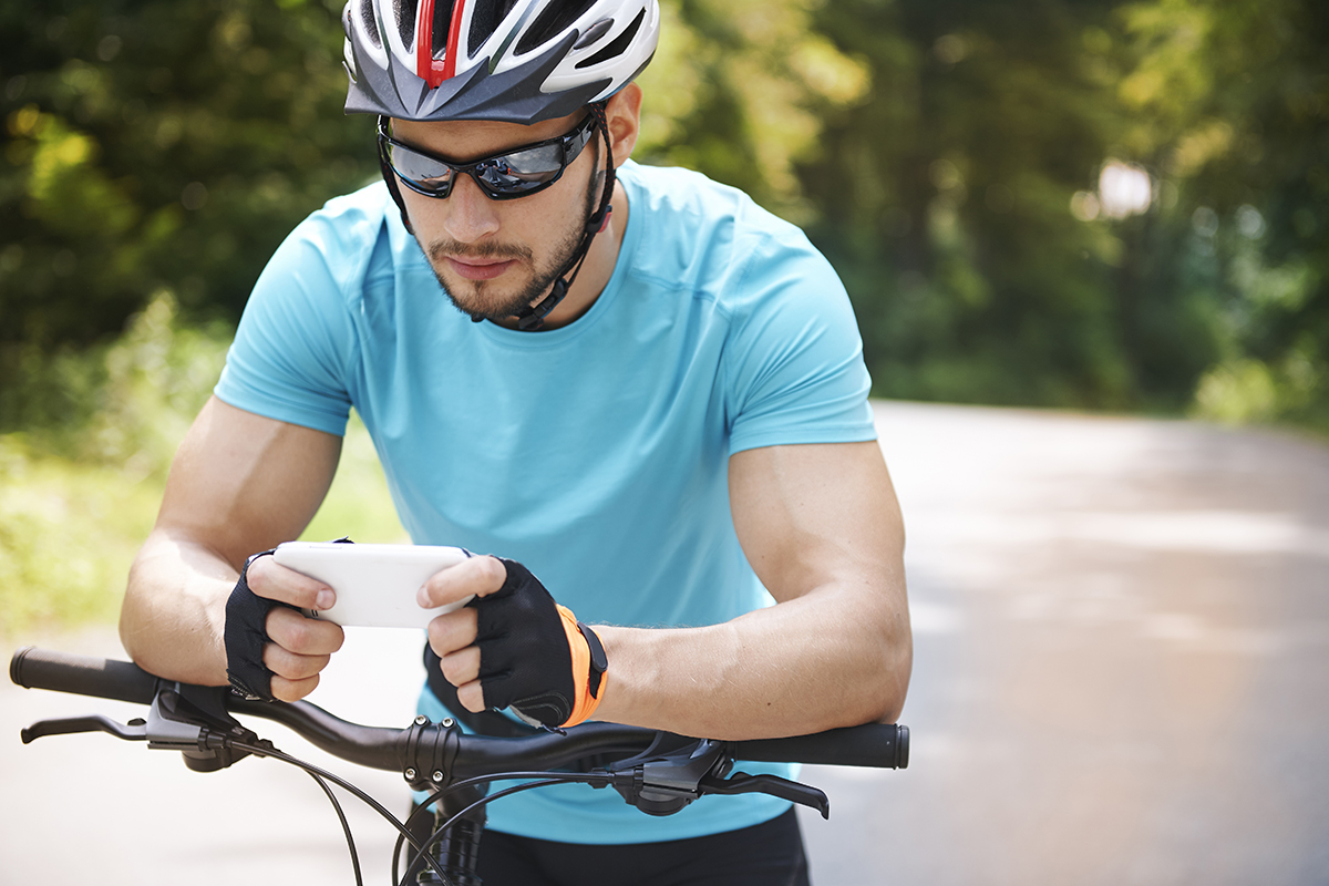 The best Apps to travel Lanzarote by bicycle - Cyclist consulting the mobile - Papagayo Bike Lanzarote The best Apps to travel Lanzarote by bicycle - Cyclist consulting the mobile - Papagayo Bike Lanzarote